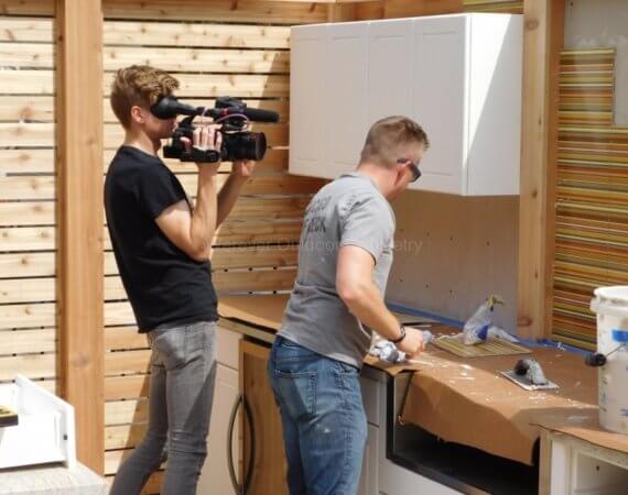 Backspash being installed on outdoor cabinets